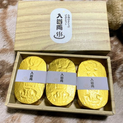 「小判のかたちのバスボムセット　入浴両（温泉マーク）」木箱風の箱　中には黄金色の小判を束ねた風の包装の「入浴両」が3個