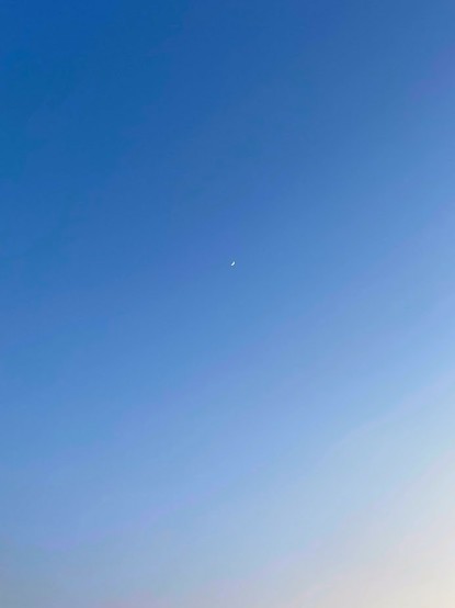 青い空　細い月　右下少しオレンジ