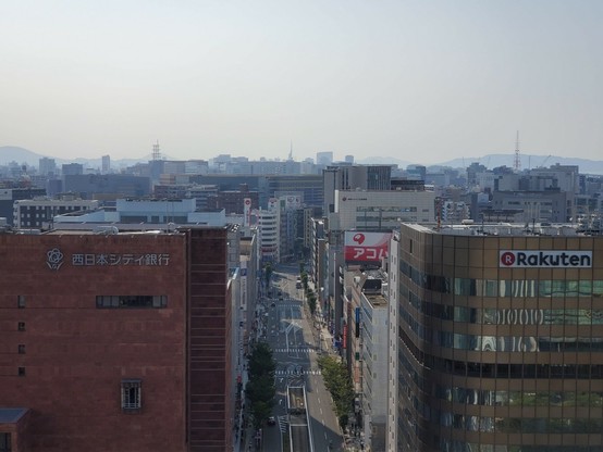 2019年9月。博多駅の屋上から西側の眺め。一番手前、赤い西日本シティ銀行本店がある。奥の方、福岡タワー、福岡ドーム、シーホークが見える。祇園町にホテルが建ったせいでアクロス福岡は上の方がちらっとしか見えない。